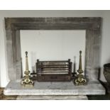 A stone fire surround with cast iron basket and brass fire dogs