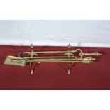 Antique brass fire dogs together with fire irons, tongs, poker and shovel