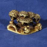 An ivory netsuke modelled as a scribe sat underneath a tree