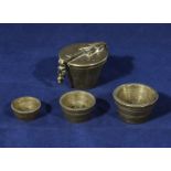 A set of brass nesting weights and cup