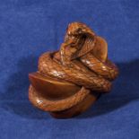 A carved wooden netsuke of a snake, signed