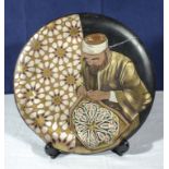 Cairo Ware 1920/30's dish depicting a craftsman applying designs to tent canvas, 29cm diameter