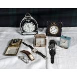 A collection of travel clocks and wrist watches