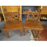 A pair of mid 19th century oak Gothic revival hall chairs having pierced backs on turned legs