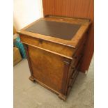 A Victorian walnut Davenport having a sliding top with fitted interior over drawers