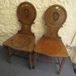 Pair of early Victorian mahogany hall chairs, the circular backs painted with a crowned crest for