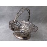 An Edwardian silver pierced basket having an ornate handle on an oval base, dated Birmingham 1914,