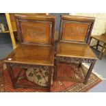 A pair of 19th century oriental rosewood side chairs having carved panelled backs on square legs