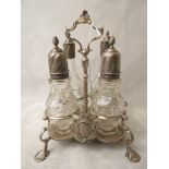 A Georgian silver condiment stand with silver mounted cut glass cruet bottles and family crest to