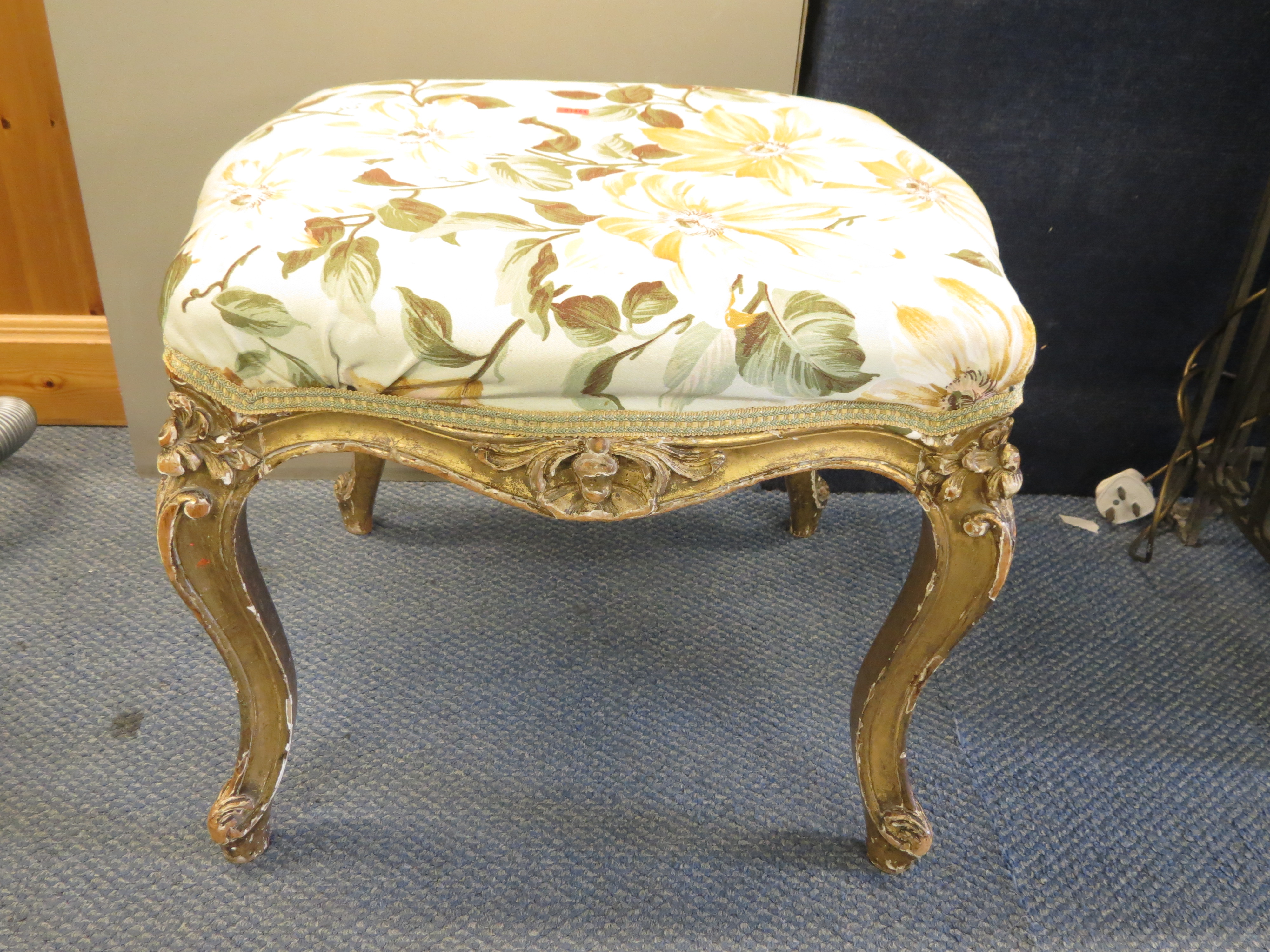A 19th century French gilt wood stool having overstuffed seat on cabriole legs
