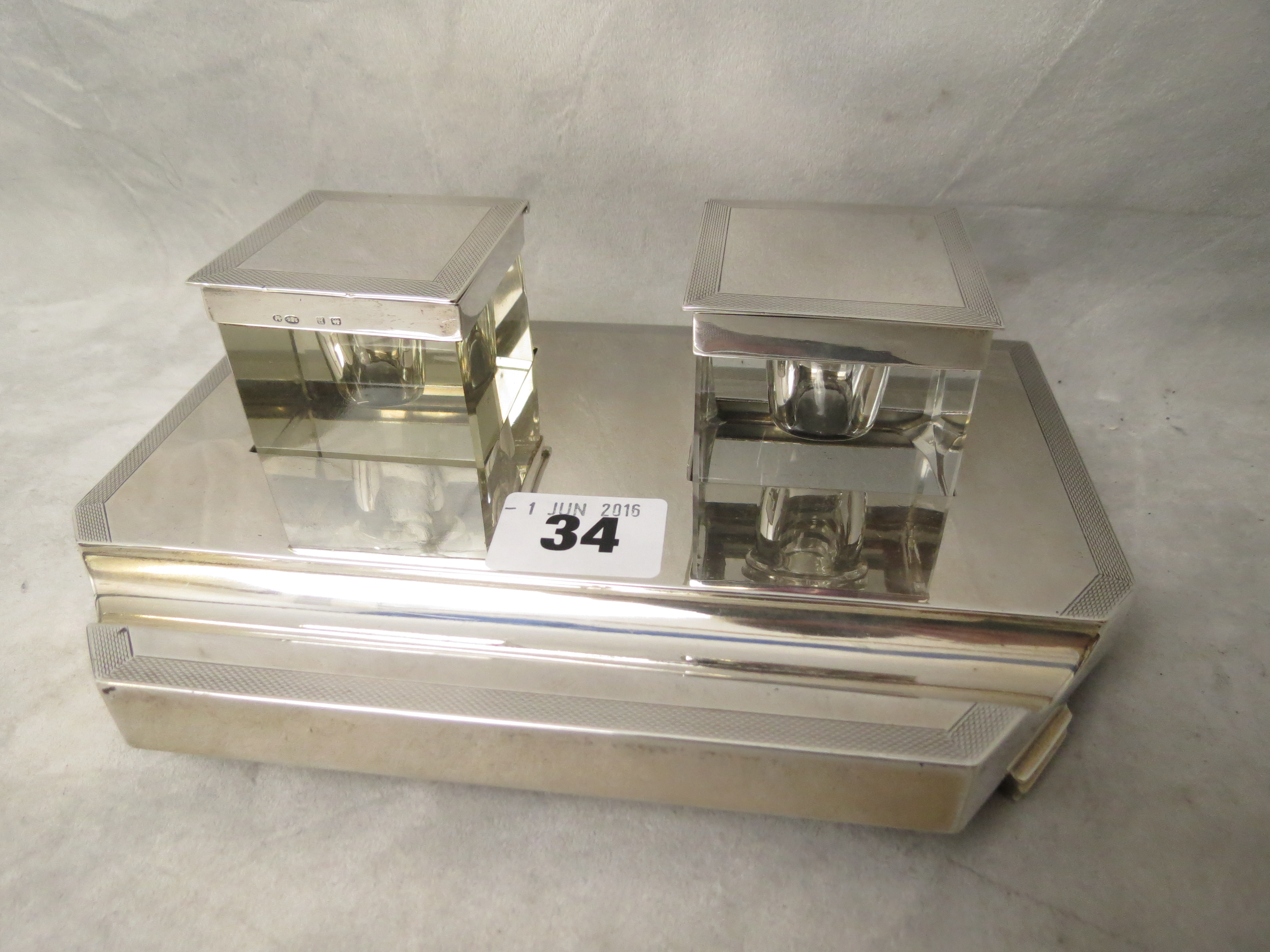 An art deco silver ink stand with two glass inkwells having silver tops (one a replacement) and a