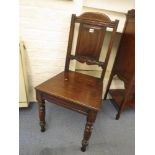 A 19th century oak hall chair having a solid seat on turned legs