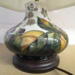 A contemporary Moorcroft table lamp decorated with a design of raspberries and leaves, with fabric