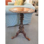 A 19th century carved circular topped wine table on turned column and splayed legs