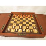 A Victorian folding travelling chess set with white ivory and red stained ivory chess pieces