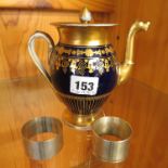 A Regency porcelain coffee pot in gilt and blue, together with two silver napkin rings