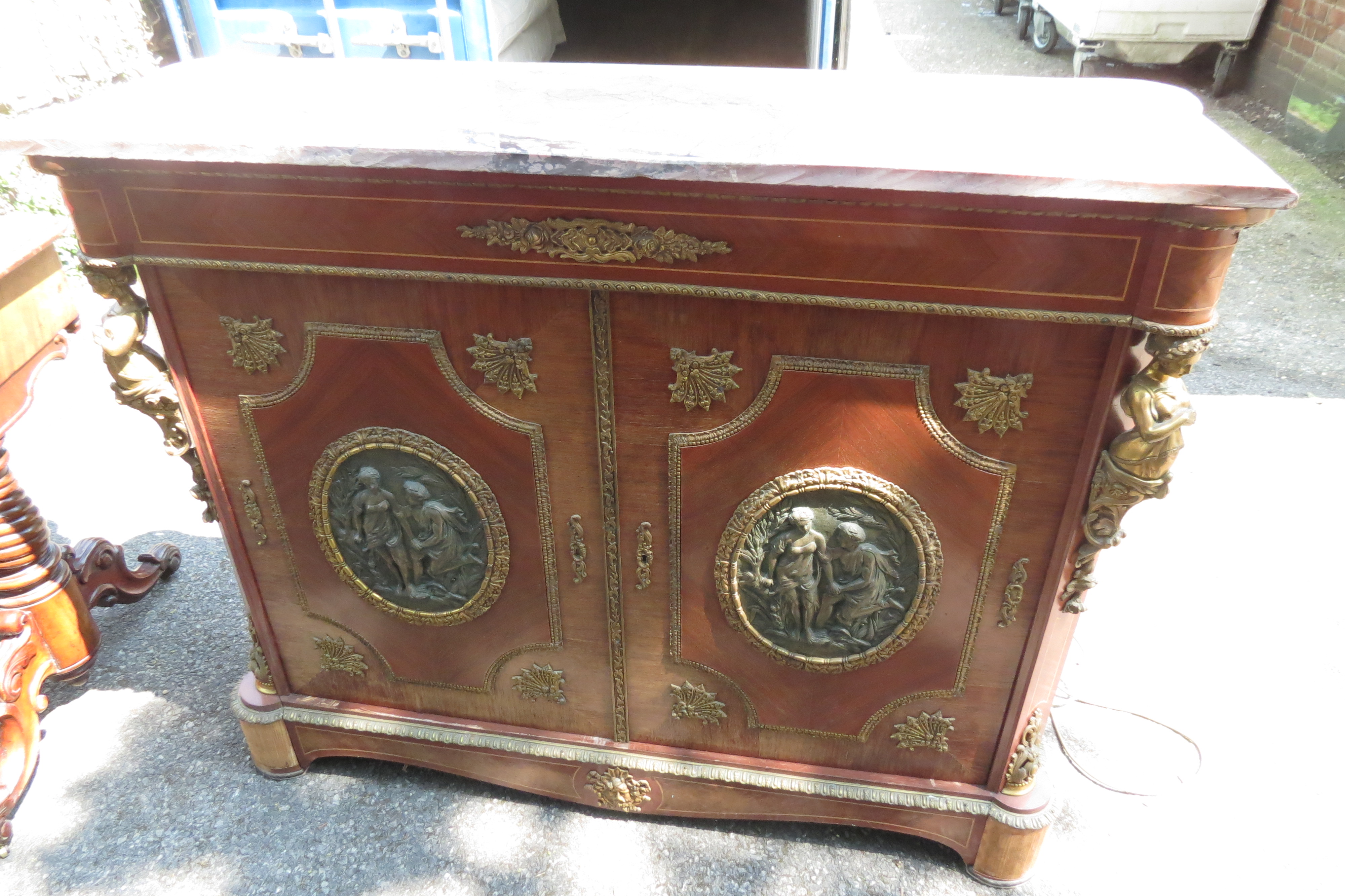 A 20th century French Empire style kingwood gilt mounted side cabinet with bronze plaques and marble