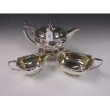 A George III silver boat shaped Teapot, Stand, Sugar Bowl, and Milk Jug with scroll borders,