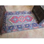 A small Persian Rug, multi-bordered with red central ground, 6ft 7in x 4ft 9in