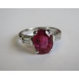 A Ruby and Diamond Ring claw -set oval-cut ruby, 3.07cts between two pairs of diamond baguettes in