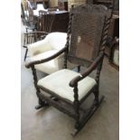 An antique walnut Rocking Chair with floral carved shaped top bar and barley twist supports