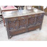 A 17th Century oak Mule Chest having four panel front carved with stylised flowers and fitted two