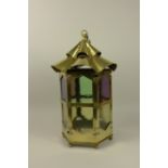 A large brass Lantern of hexagonal form with coloured glass panels, 19in H