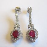 A pair of Ruby and Diamond Ear Pendants each claw-set oval-cut ruby, approx 0.70cts, within a