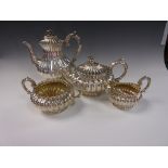 A George IV silver Tea and Coffee Service of circular fluted form with leafage scroll handles, the