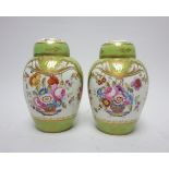 A pair of Rockingham ovoid Teapoys and Covers painted baskets of flowers in coloured enamels apple