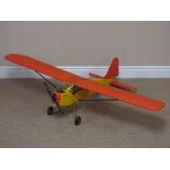 A radio controlled single engined high winged Aircraft with yellow fuselage including petrol motor