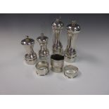 Two pairs of silver Pepper Mills and four various Napkin Rings