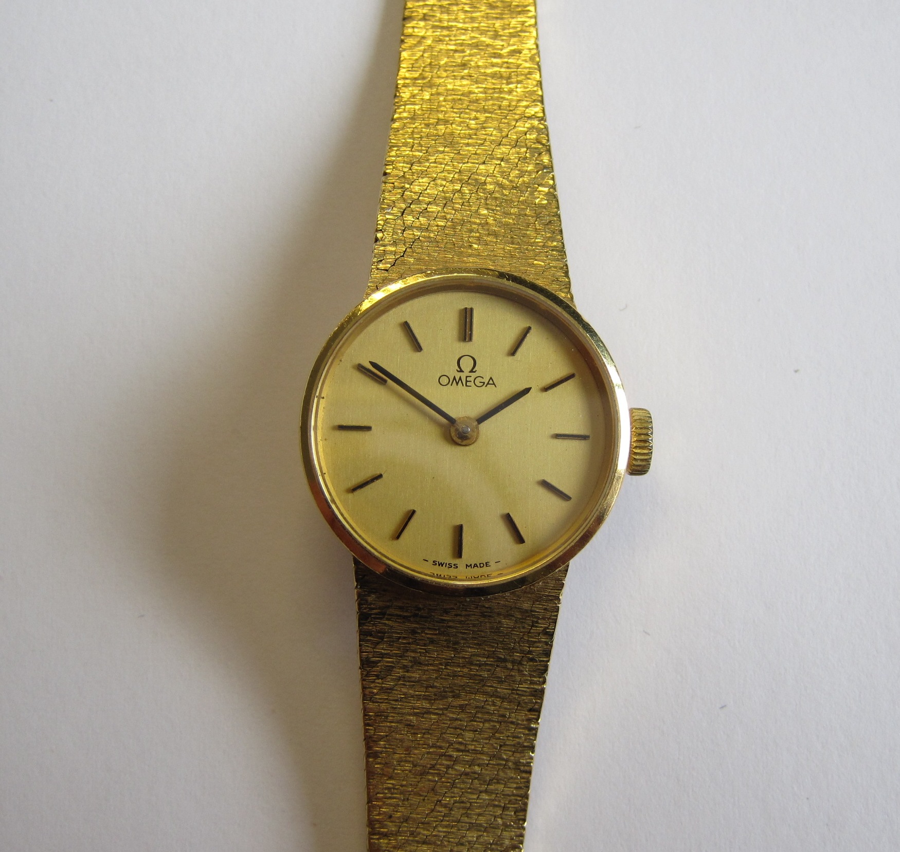 A Lady's Omega Wristwatch the champagne dial with applied gold baton hourly markers on textured