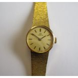 A Lady's Omega Wristwatch the champagne dial with applied gold baton hourly markers on textured