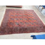 An Afgan Nahzat Carpet of multi-bordered design with rows of medallions on a red ground, 8ft 9in x