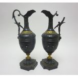 A pair of 19th Century small bronze Ewers decorated flowers in relief, leafage friezes on black