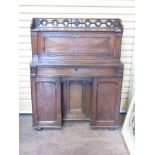 A late 19th Century small oak Desk with pierced frieze above fall front enclosing pigeon holes,