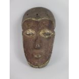 A Central African (possibly Lwalwa) carved Mask with brown pigment and kaolin detail