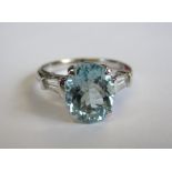 An Aquamarine and Diamond Ring claw-set oval-cut aquamarine between two tapered diamond baguettes in