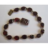 A Garnet Bracelet close-set row of oval-cut stones, on box clasp set numerous stones