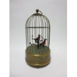 A brass wirework Linnet Cage with two birds having musical movement, 11in