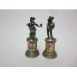 A pair of Continental silver Figures of flower girl and musician on circular pedestals enamelled