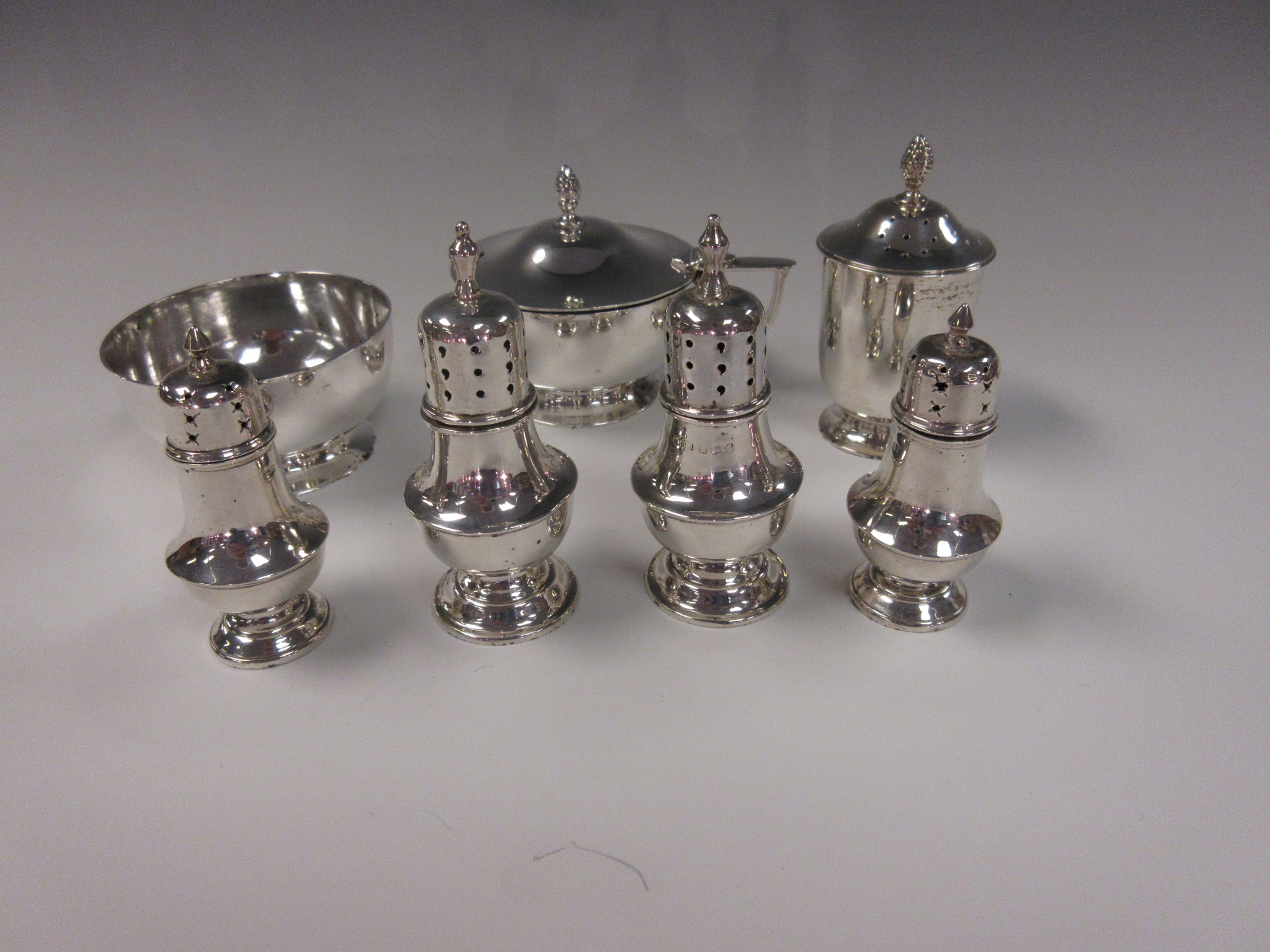 A George VI silver three piece Condiment Set of plain circular form, Birmingham 1945 and two pairs