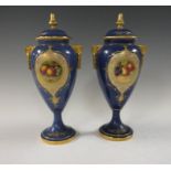 A pair of Royal Worcester Vases and Covers painted panels of fruit , decorative border, on a
