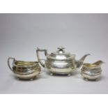 A George III/IV silver three piece Tea Service of boat shape with scallop, leafage and gadroon