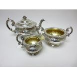 A George IV Scottish silver three piece Tea Service with floral embossing and vacant cartouches,