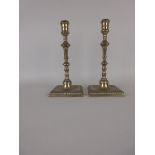 A pair of Paktong Pillar Candlesticks with knopped stems on square bases with domed and dished