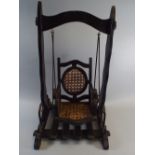 An Early 20th Century Painted Wood Dolls Swing. The Seat with a Cane Back and Sides.