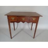 An Edwardian Crossbanded Mahogany Side Table with Three Drawers on Tapering Square Legs,