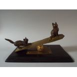 A Novelty Desk Top Paper Clip in the form of Two Cats Playing on Seesaw. On Mahogany Plinth.